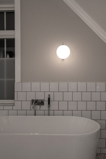 Hovedbad med nydelige detaljer og materialer. Brystpanel i hvit flis og slette beige vegger