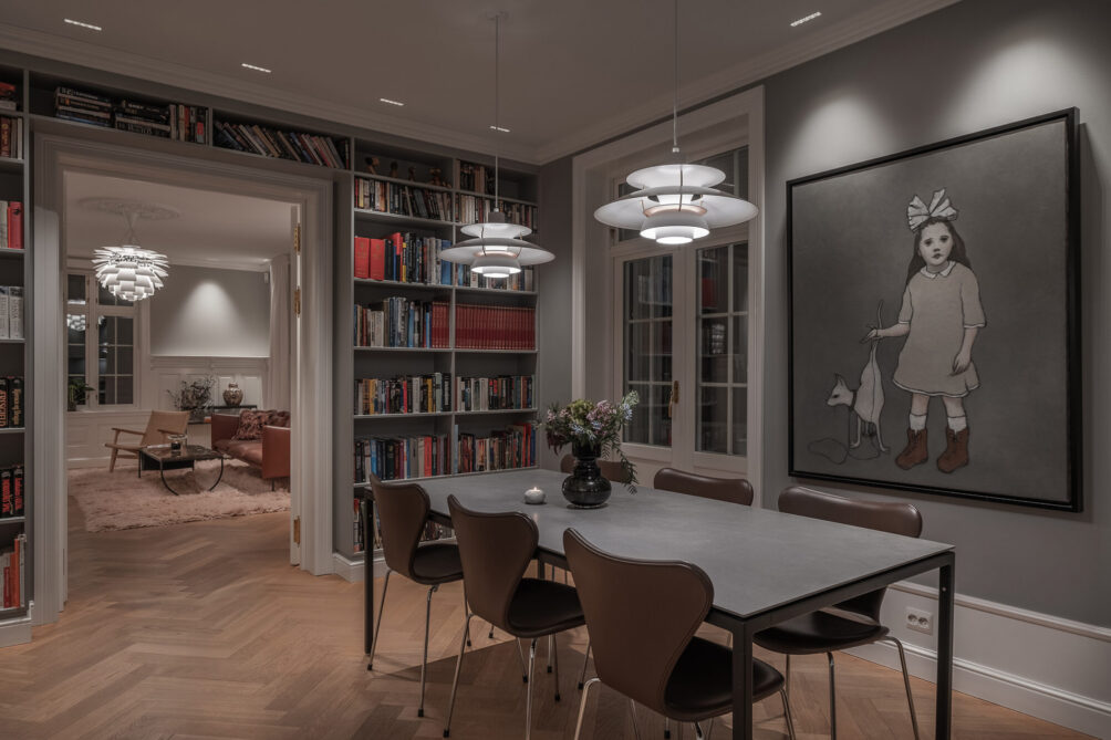 Kjøkken designet med gråtoner kombinert med skinn og bokhyller, designet av eksponeringsdesigner ved Lyngstad Arkitekter